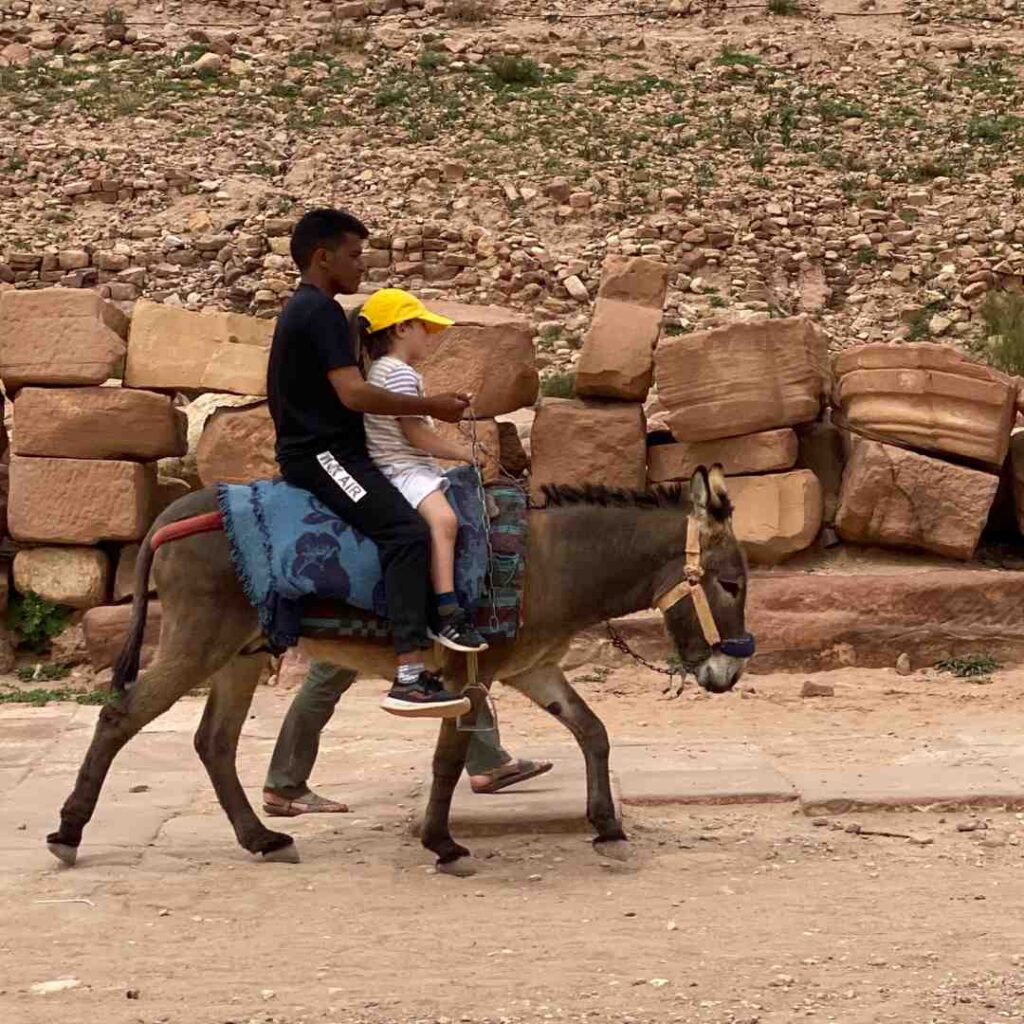 Two people riding a donkey.