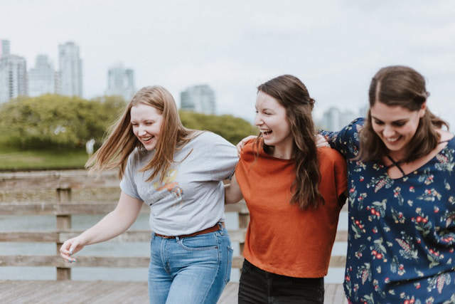 A group of three friends laughing and smiling.