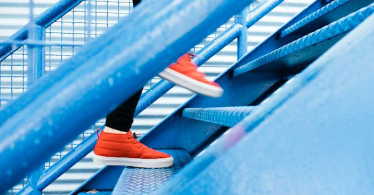 Bright orange shoes going up stairs.